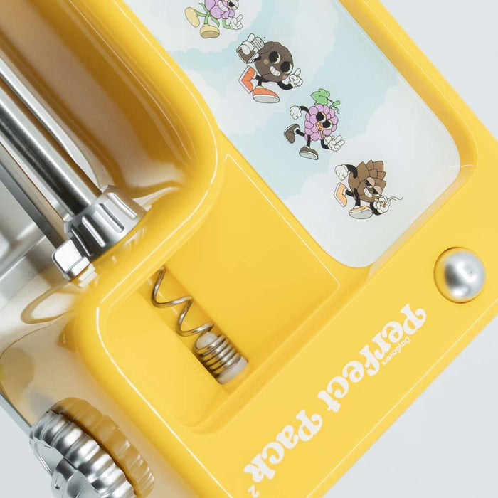Close-up of yellow DaySavers filling machine with adjustment mechanism and spring assembly