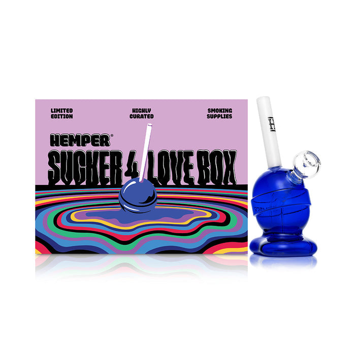 Hemper lollipop glass bong beside branded box, candy-style detailing with included bowl for compact smooth dry herb pulls