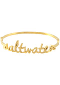 Wanderlust + Co Saltwater Bangle in gold with cursive saltwater script on 24k plated stainless steel hinged bangle bracelet — front view