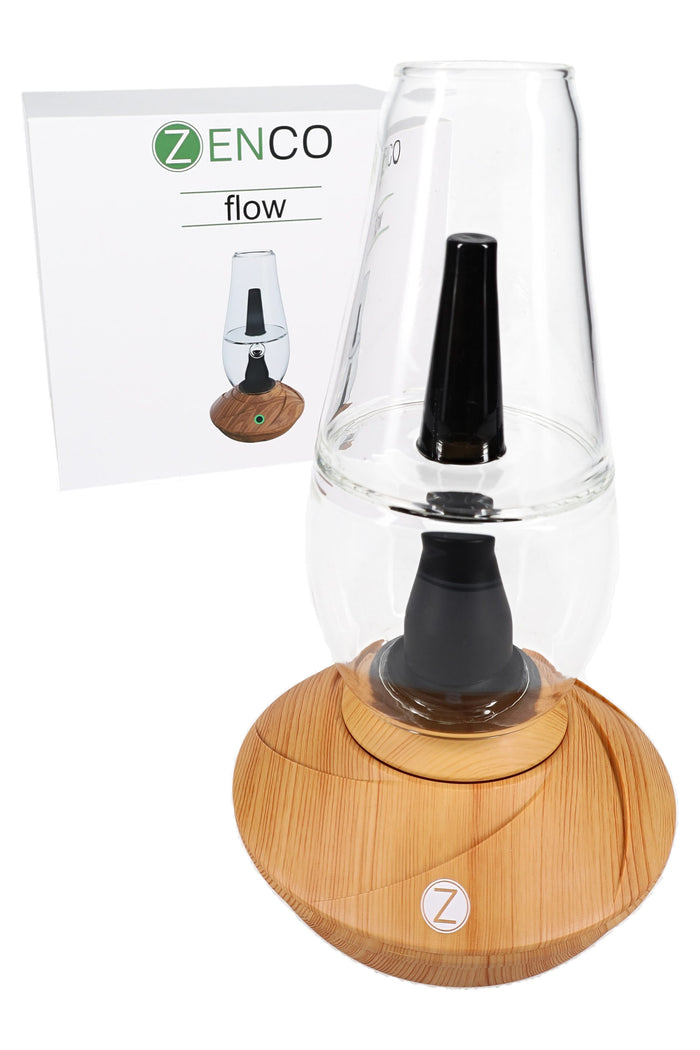 Zenco Flow vaporizer in wood finish displayed beside retail box, showing glass water cup, black mouthpiece, and compact desktop base.